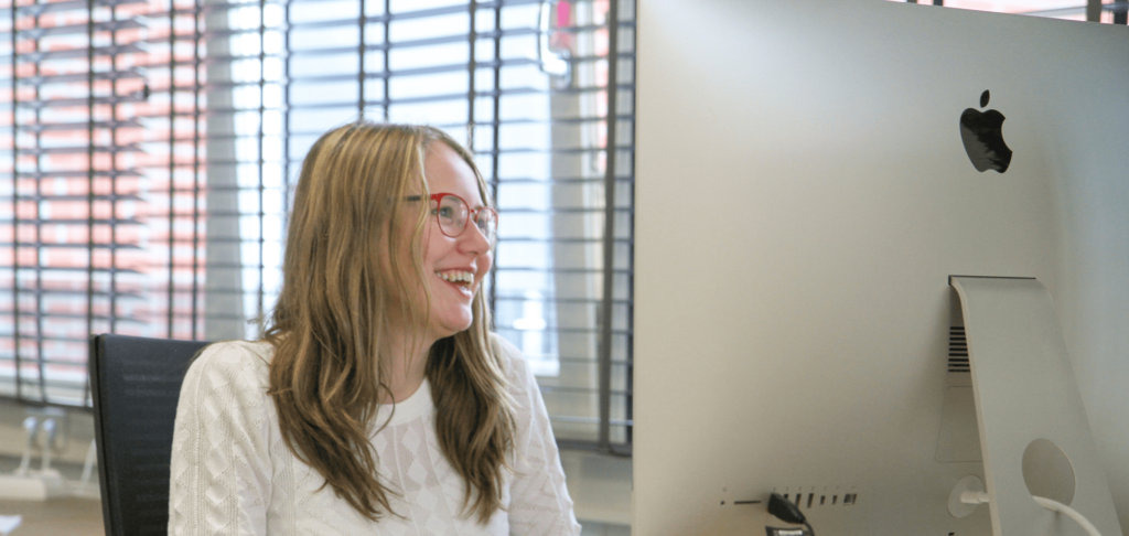 Foto over mij, Britt, op stage lachend achter mijn iMac op o.a. de homepagina.