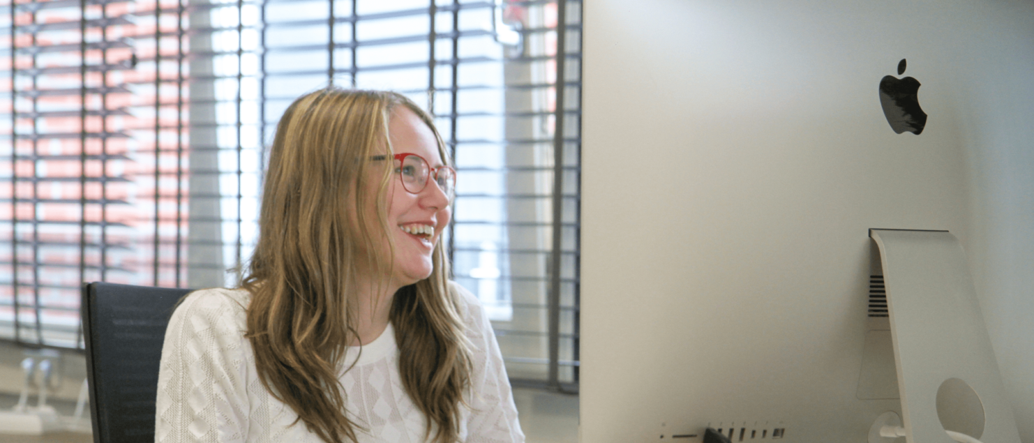 Foto over mij, Britt, op stage lachend achter mijn iMac op o.a. de homepagina.